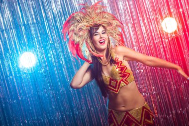 Karnaval, oryantal dans ve tatil konsepti - Altın kostüm giyen ve gülümseyen güzel kadın samba dansçısı