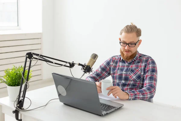 Anfitrión de radio, streamer y blogger concepto - Hombre guapo trabajando como locutor de radio en la estación de radio sentado frente al micrófono — Foto de Stock