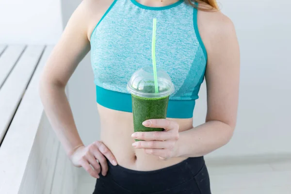 Concetto sano, fitness e disintossicazione - primo piano della giovane donna in abbigliamento sportivo con frullato verde all'interno — Foto Stock