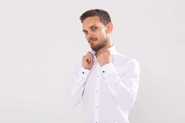 Retrato de belo jovem feliz em camisa casual em pé contra fundo branco com espaço de cópia — Fotografia de Stock