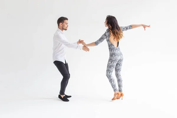Casal jovem dançando bachata dança latina social, merengue, salsa. Dois pose elegância no fundo branco — Fotografia de Stock