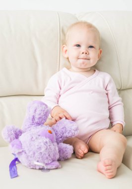 çocukluk, bebeklik ve insan kavramı - evde kanepede oturan mutlu küçük bebek kız