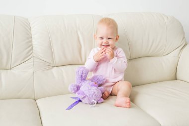 Çocuklar, bebek ve çocukluk konsepti - güzel gülümseyen bebek oturma