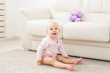 Çocuklar, bebek ve çocukluk konsepti - Güzel sevimli yumuşak bebek kanepede oturan