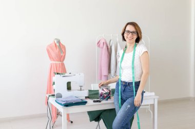 Terzi, moda tasarımcısı, terzi ve insanlar kavramı - güzel moda kadın Tasarımcısı stüdyoda ayakta