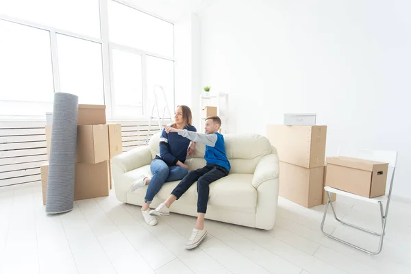 Schattige alleenstaande moeder en kleine jongen zoon ontspannen na de verhuizing. Het concept van een Inwijdingsfeest hypotheek en de vreugde van nieuwe woningen. — Stockfoto