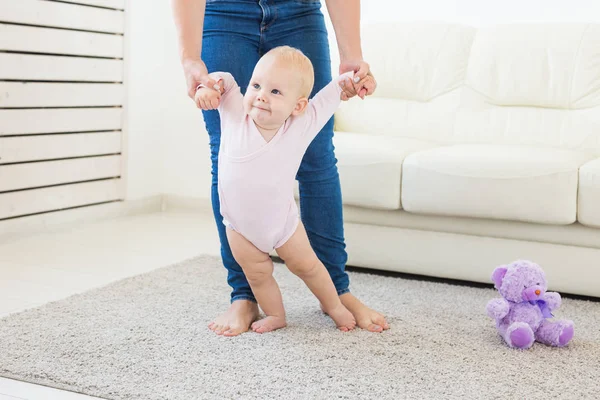 Kleines Mädchen erste Schritte mit der Hilfe von Mama — Stockfoto