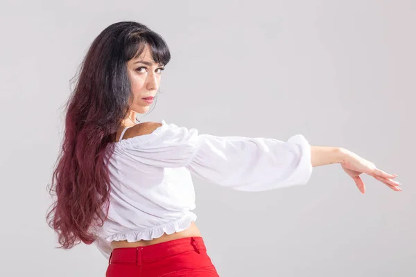 Latina dance, strip dance, contemporary and bachata lady concept - Woman dancing improvisation and moving her long hair on a white background