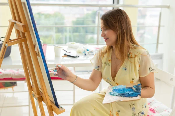 アートクラスとドローイングコンセプト - スタジオで絵画に取り組む女性アーティスト. — ストック写真