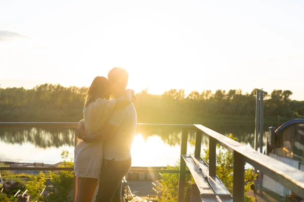 Maravilhoso jovem casal abraçar e desfrutar da vida em conjunto com a atividade natural de lazer ao ar livre estilo de vida na natureza eo pôr do sol na luz de fundo . — Fotografia de Stock