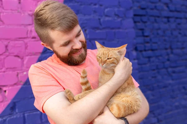 Conceito de amizade e animais de estimação - Bonito jovem com gato bonito ao ar livre — Fotografia de Stock