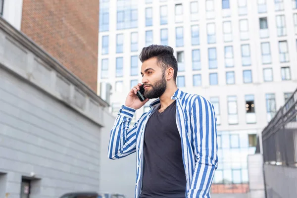 Hombre joven árabe moderno con teléfono móvil en la calle. Retrato exterior . — Foto de Stock