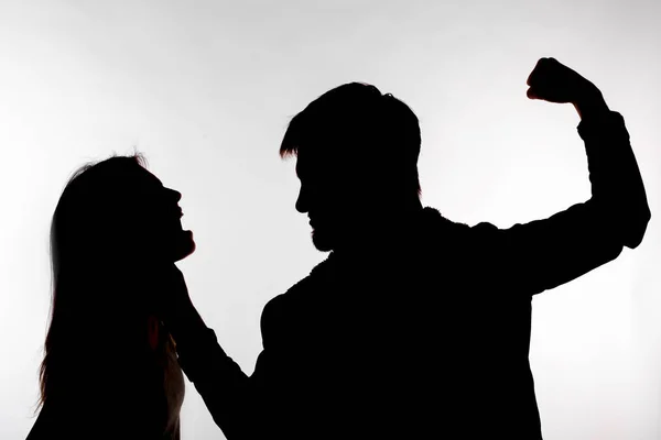 Domestic violence and abuse concept - Silhouette of man beating defenseless woman — Stock Photo, Image