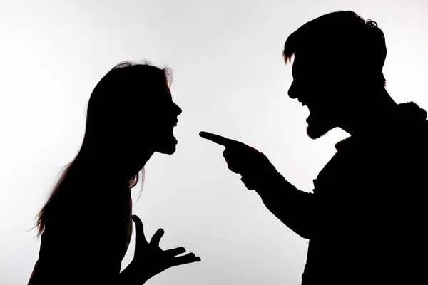 Aggression and abuse concept - man and woman expressing domestic violence in studio silhouette isolated on white background. — Stock Photo, Image