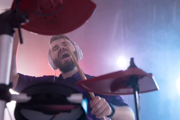 Эмоции, ударные, хобби и концепция людей - рок-музыкант, играющий на барабанах на сцене — стоковое фото