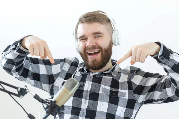 Podcasting, música y concepto de radio - Hombre feliz con micrófono y auriculares grandes — Foto de Stock