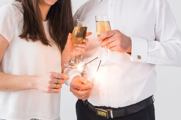 Handen dicht met sterretjes en champagneglazen. Vuurwerk vieren 's nachts gelukkig nieuwjaar — Stockfoto