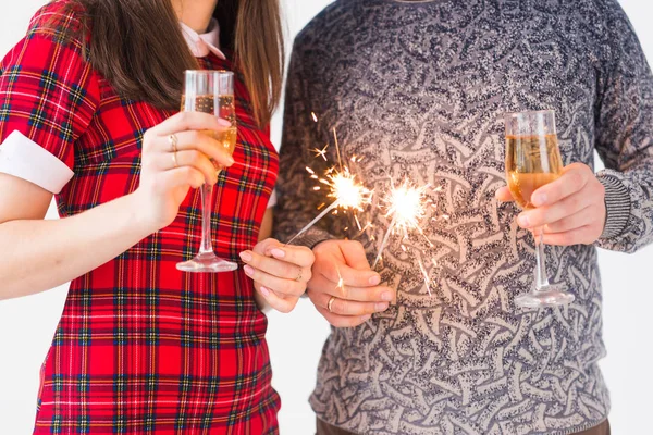 Primo piano di mani che tengono scintillanti e bicchieri di champagne. Fuochi d'artificio festeggiare di notte felice anno nuovo — Foto Stock