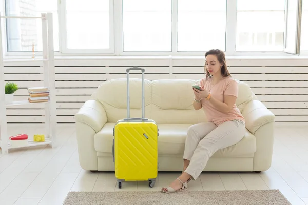 Concepto de viaje, viaje y vacaciones: la mujer con una maleta amarilla está esperando el taxi — Foto de Stock