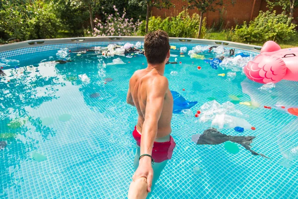 Ecologie, plastic afval, milieu nood en watervervuiling-Guy leiden in een zwembad met vuilnis — Stockfoto