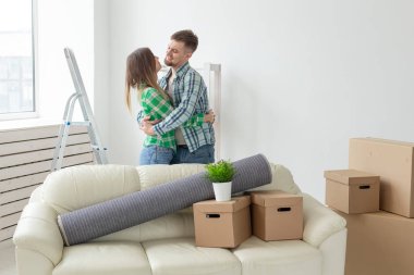 Denim pantolon genç çift hareket sırasında yeni dairede sevincini kucaklayan. Yeni konut için housewarming ve kredi kavramı.