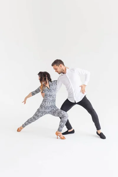 Pareja joven bailando baile latino bachata, merengue, salsa, kizomba. Dos poses de elegancia sobre fondo blanco con espacio para copiar — Foto de Stock