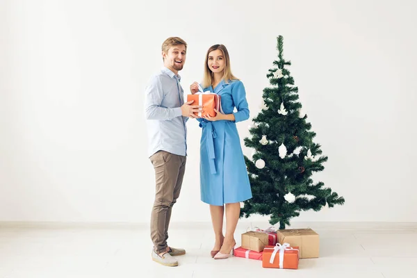 Árvore de Natal e conceito de feriados - Feliz família sorridente vestindo chapéus de Papai Noel celebrando em casa . — Fotografia de Stock