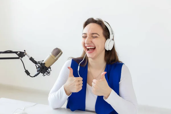 Radio, blogging, broadcast concept - Young woman working on the radio and showing thumbs up — Stock Photo, Image