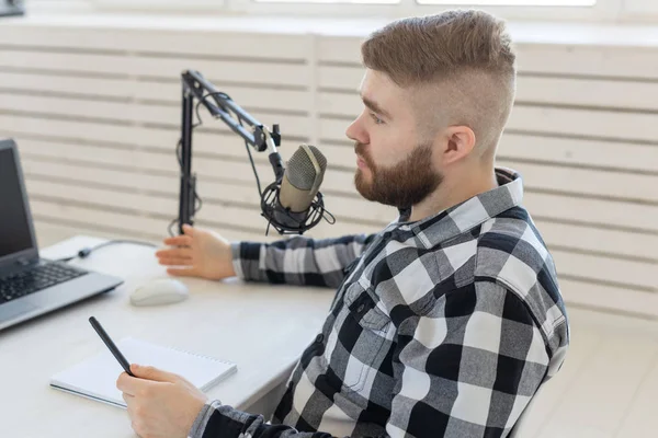 Radio Host Concept-porträtt av rolig vacker skäggiga man sitter framför mikrofonen — Stockfoto