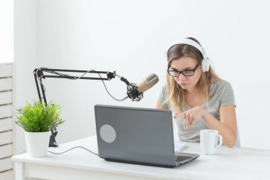 Radyo, dj, blogger ve insan kavramı - genç kadın sunucu radyo stüdyosunda çalışan ve mikrofon üzerinde konuşurken