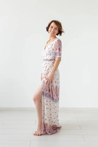 Concepto de personas, moda y estilo - mujer joven posando en la ropa en el estudio sobre fondo blanco —  Fotos de Stock