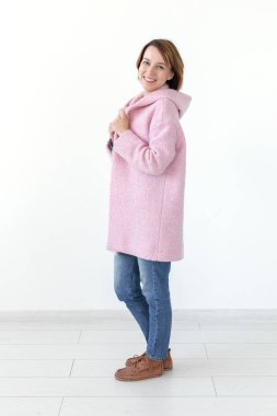 Büyüleyici genç kadın model bir tasarımcı pembe ceket beyaz bir arka plan üzerinde poz. Benzersiz bir el sanatları tasarımı kavramı. Reklam alanı, copyspace