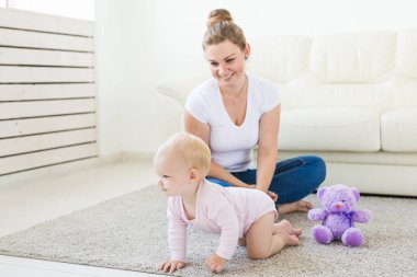 Genç mutlu sevgi dolu anne ve onun bebek kızı oynuyor. Anne bakımı. Çocuk bakımı.