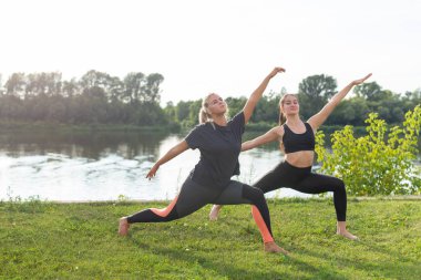 Sağlıklı yaşam tarzı ve uyum kavramı - Genç kızlar açık yoga yapıyor