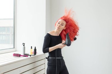 Stilist, moda, kuaför, insan kavramı - kadın onu renkli saç kurutma