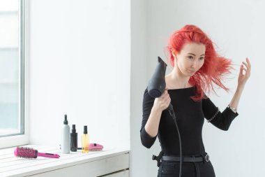 Kuaför, güzellik salonu ve insan kavramı - beyaz arka plan üzerinde saç kurutma makinesi ile genç kadın saç stilisti