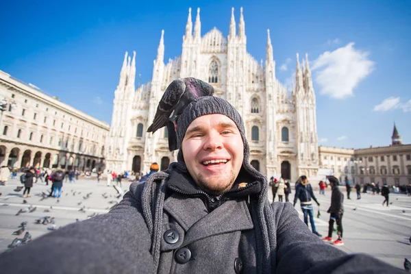 Italie, concept d'excursion et de voyage - un drôle de type qui prend des selfies avec des pigeons devant la cathédrale Duomo de Milan — Photo
