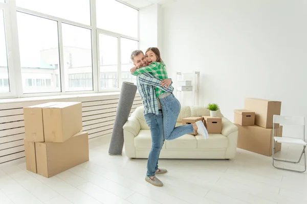 Переезд, недвижимость и трогательная концепция - Молодая веселая пара переезжает в новый дом — стоковое фото