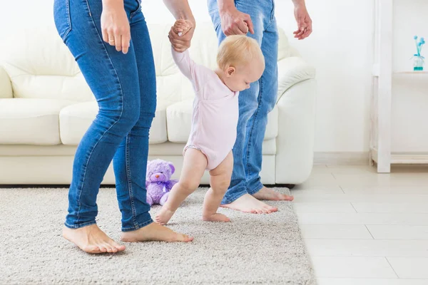 Baby véve az első lépéseket az anyák és apák segítségével otthon — Stock Fotó