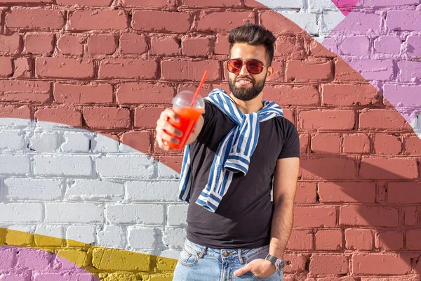 콧수염과 수염을 가진 귀여운 세련된 아랍 젊은 남성 힙스터와 빨대와 주스를 마시는 안경을 착용. 여름 방학 컨셉. — 스톡 사진