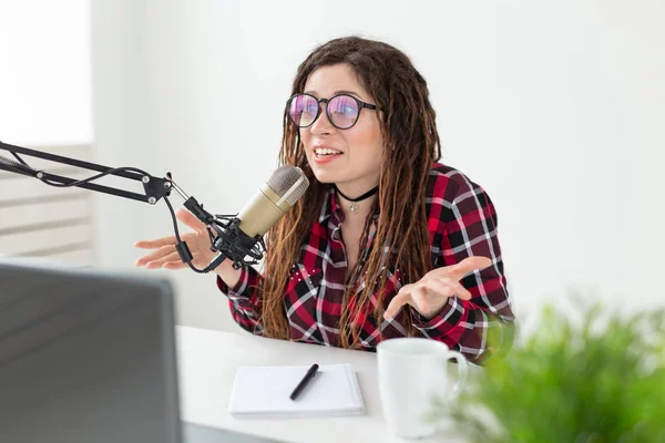 Broadcast, music, dj and people concept - woman with dreadlocks and glasses working at the radio — Stock Photo, Image