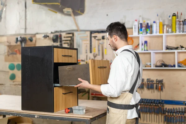 Fábrica de muebles, concepto de pequeñas empresas y personas: joven que trabaja en la producción de muebles —  Fotos de Stock