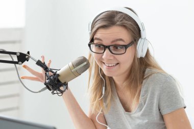 Radyo, bloglama, podcasting kavramı - radyoda dj olarak çalışan genç kadının yakın çekim.