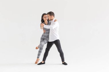 Dans eden genç çift Latin dansı bachata, merengue, salsa. Telif boşluğunda beyaz arkaplanda iki zarafet pozu