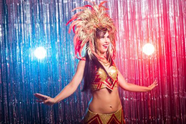 Karnaval, oryantal dans ve tatil konsepti - Altın kostüm giyen ve gülümseyen güzel kadın samba dansçısı