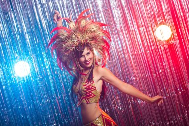 Karnaval, oryantal dans ve tatil konsepti - Altın kostüm giyen ve gülümseyen güzel kadın samba dansçısı