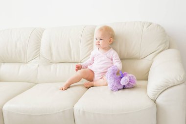 Çocuklar, bebek ve çocukluk konsepti - güzel gülümseyen bebek oturma