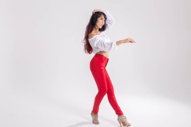 Latin dansı, striptiz dansı, çağdaş ve bachata bayan konsepti - doğaçlama dans eden ve uzun saçlarını beyaz arka planda gezdiren kadın
