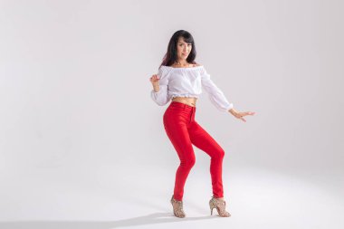 Latin dansı, striptiz dansı, çağdaş ve bachata kadın konsepti - doğaçlama dans eden ve uzun saçlarını fotokopi alanı olan beyaz bir arka planda hareket ettiren kadın