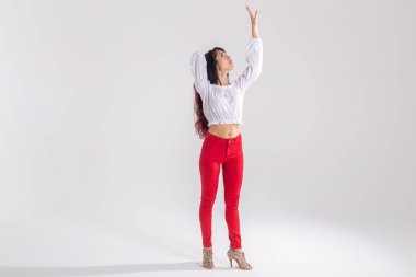 Latin dansı, striptiz dansı, çağdaş ve bachata kadın konsepti - doğaçlama dans eden ve uzun saçlarını fotokopi alanı olan beyaz bir arka planda hareket ettiren kadın